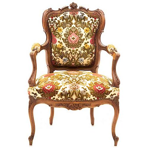 Sillón. Francia. Siglo XX. Estilo Luis XV. En talla de madera. Con respaldo cerrado y asiento en tapicería floral.