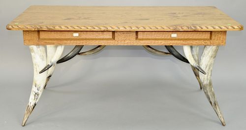 Milo Marks Desk, having steer horn legs and skirt, two drawers with antler handles and rope carved edge top. height 30 1/2 inches, top: 32" x 64 1/2".