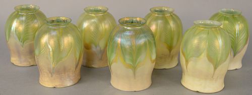 Set of Seven Tiffany Shades, floriform with opalescent green and gold pulled feather design, all marked L.C.T. height 5 inches, diameter 3 1/4 inches.