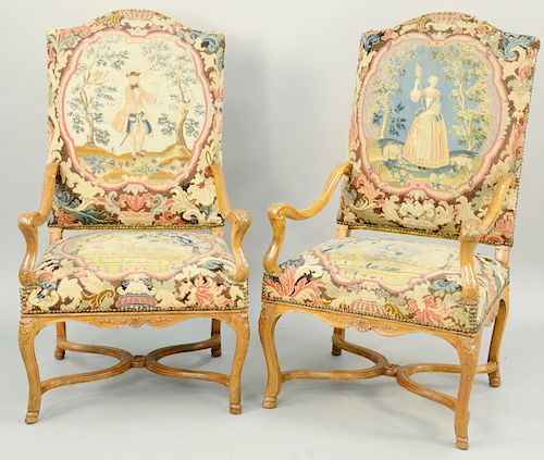 Pair of Louis XIV Needlepoint Upholstered Walnut Armchairs, shaped crest with open scroll arms, over cabriole legs ending in hoof feet, all carved wit