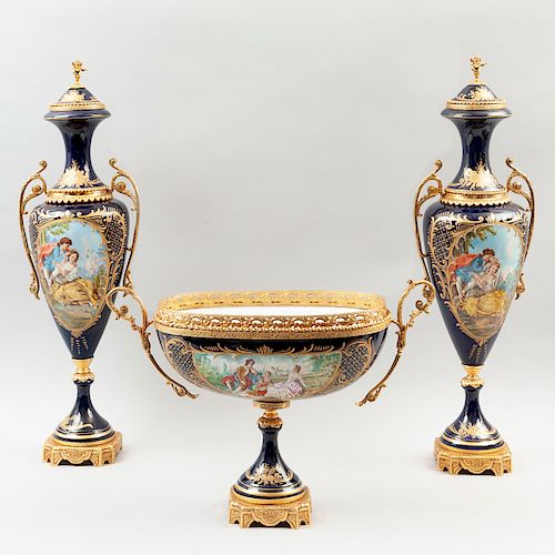 Guarnición. Origen europeo, siglo XX. En porcelana tipo Sèvres azul cobalto con aplicaciones de metal dorado. Pz: 3