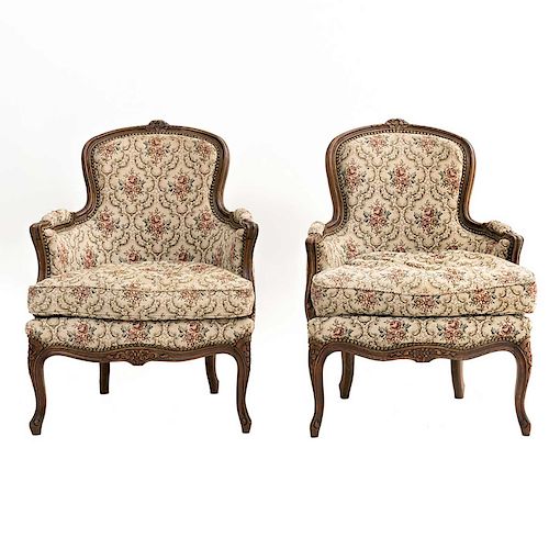 Par de sillones. Francia. SXX. Estilo Luis XV. En madera de nogal. Con respaldos cerrados y asientos con cojín en tapicería floral.