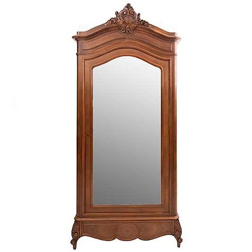 Armario. Francia. Siglo XX. En talla de madera de nogal. Con puerta con espejo de luna biselada y cajón. 249 x 110 x 50 cm.