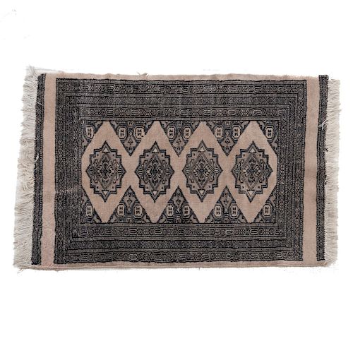 Tapete. Pakistán. Siglo XX. Estilo Boukhara. Anudada a mano en fibras de lana. Decorada con elementos geométricos. 94 x 62 cm.