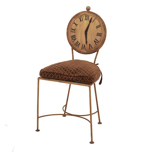 Silla. Siglo XX. En talla de madera. Con respaldo a manera de reloj y asiento con cojín en tapicería color marrón.