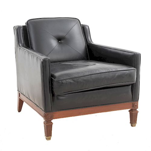 Sillón. Siglo XX. En talla de madera. Con respaldo cerrado con cojín y asiento con cojín en piel color negro.