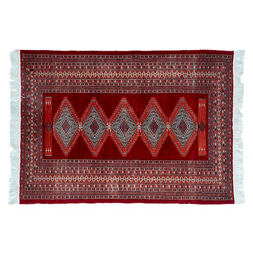 Tapete. Pakistán, siglo XX. Estilo Bokhara. Anudado a mano en fibras de lana y algodón. Decorado con motivos geométricos.