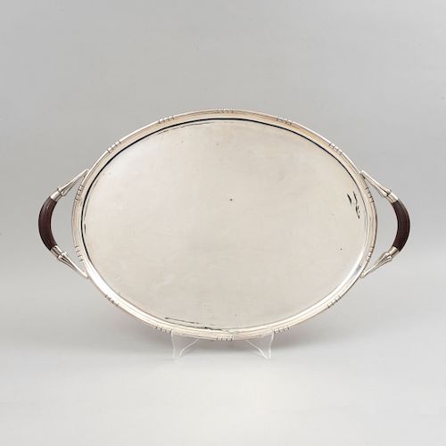 Charola. México, siglo XX. Diseño oval. Elaborada en plata Sterling, Ley 0.925. con aplicaciones de teca. Peso total: 2290 g