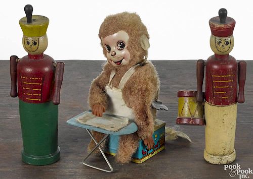 Tin wind-up ironing monkey, 20th c., 6 1/2'' h., together with two painted wood soldiers, 7 1/4'' h.