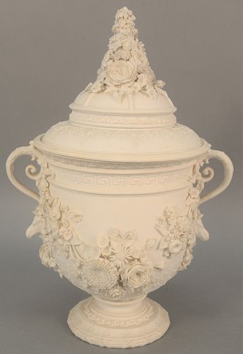 Large Bisque covered urn having two handles and molded flowers. ht. 18 in., wd. 13 in. Provenance: The Estate of Ed Brenner, Short Hills N.J.