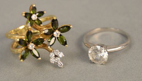 Two 18K gold rings, one white gold, size 6 3/4, one floral pattern with diamonds and green stones, size 8 1/2. total weight 16.1 grams.