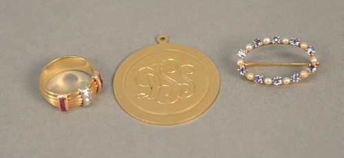 Three piece lot to include 14K gold oval pin and ring set with small diamonds and rubies, size 4, plus a large charm. total weight 14 grams.