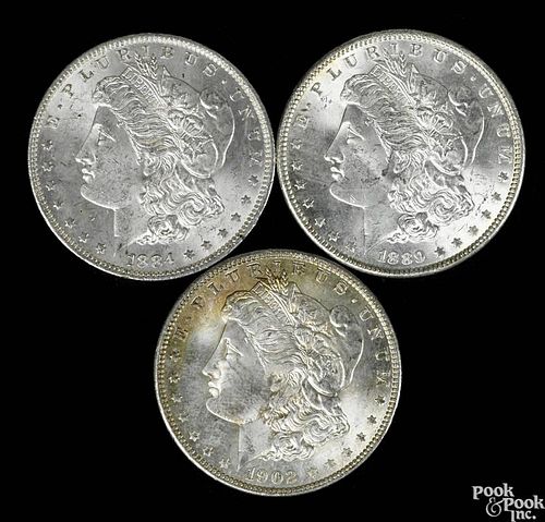 Three Morgan silver dollars, to include an 1884 O, UNC, an 1889, UNC, and a 1902 O, UNC.
