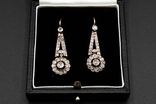 A PAIR OF DIAMOND SET EARRINGS, with flower head mount to the bottom of a t