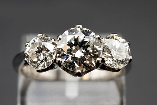 A DIAMOND AND PLATINUM RING, the three brilliant cut diamonds claw set in a