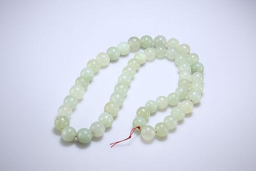 A STRING OF JADE BEADS, the forty-nine beads slightly graduating. Approx. 6