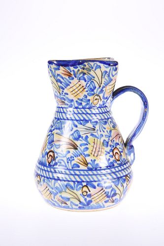 A SPANISH FAIENCE JUG, 19TH CENTURY, with strap handle. 19.5cm