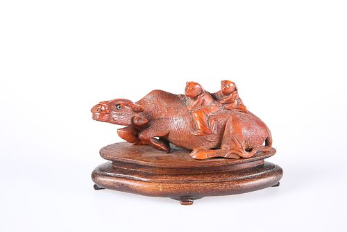 A CHINESE CINNABAR LACQUER MODEL OF A BUFFALO, modelled with two children o
