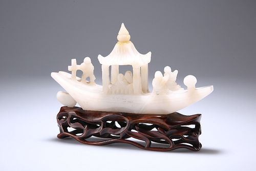 AN EARLY 20TH CENTURY CHINESE JADE MODEL OF A RIVER BOAT, on a wooden stand