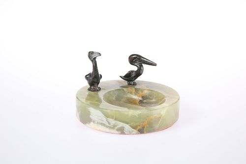AN ONYX ASHTRAY MOUNTED WITH TWO BRONZE MODELS OF PELICANS. Diameter 10cm