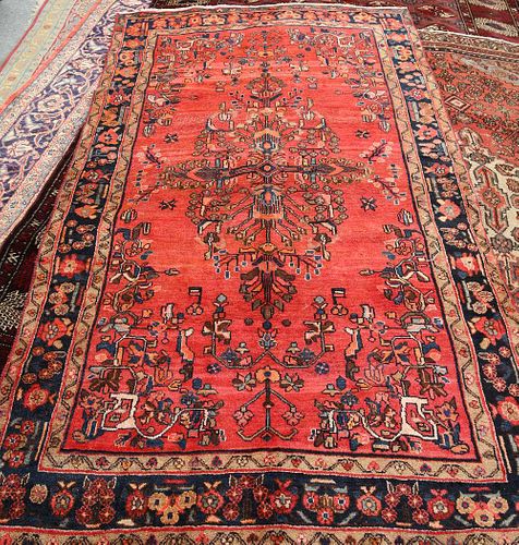 A LILIAN CARPET, with large central motif on a red ground, dark blue border