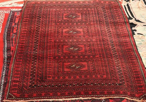 A BALOUCH RUG, with four centre reserves and a red ground, circa 1950. 184c
