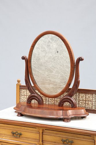 A VICTORIAN MAHOGANY TOILET MIRROR, the oval mirror plate swinging between 