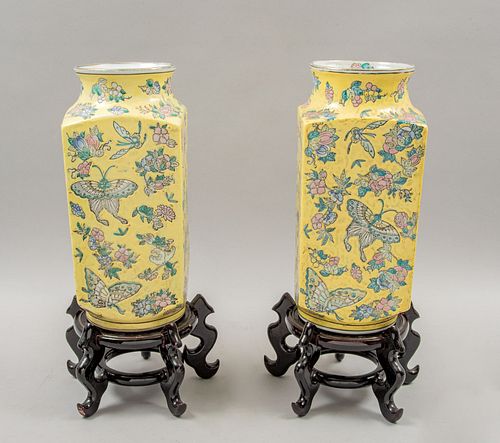 Par de floreros. China, años 80. Elaborados en cerámica amarilla con bases de madera. Decoradas con mariposas y motivos florales.