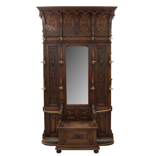 Perchero-paragüero. Francia. SXX. Estilo Enrique II. En talla de madera de nogal. Con 12 ganchos, espejo y asiento. 253 x 140 x 43 cm.
