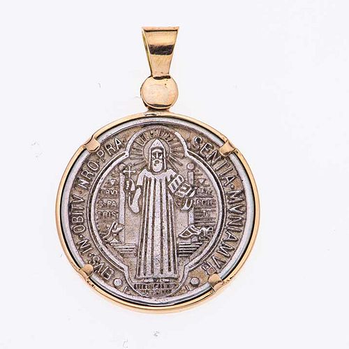 Medalla en plata .925  y oro amarillo de 14k. Imagen de San Benito. Peso: 5.5 g.