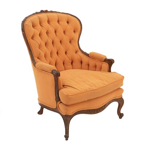 Sillón. Siglo XX. En talla de madera. En tapicería color amarillo. Con respaldo cerrado capitonado y asiento con cojín.