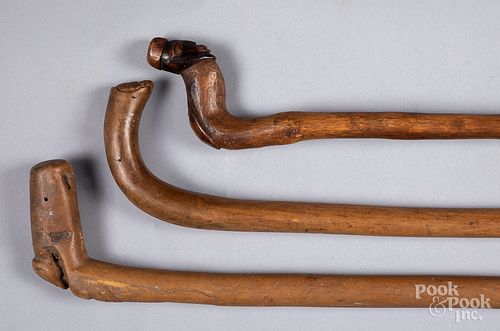 Three carved canes with figural grips.