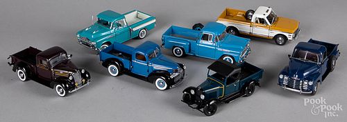 Seven Danbury Mint scale model pick-up trucks.