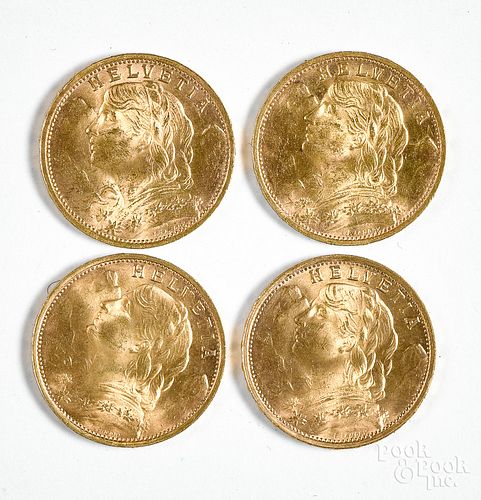 Four Helvetia 20 Franc gold coins.