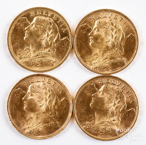 Four Helvetia 20 franc gold coins.