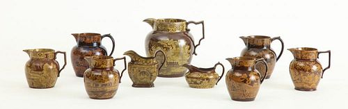 GROUP OF SEVEN STAFFORDSHIRE BROWN-GLAZED YELLOW TRANSFERWARE PITCHERS AND TWO CREAMERS