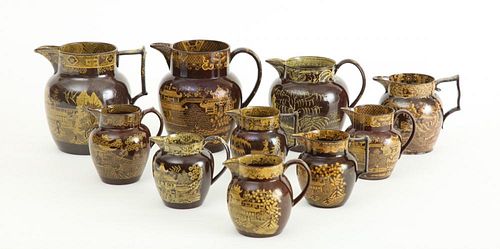 GROUP OF TEN STAFFORDSHIRE BROWN-GLAZED YELLOW TRANSFERWARE DECORATED PITCHERS AND JUGS