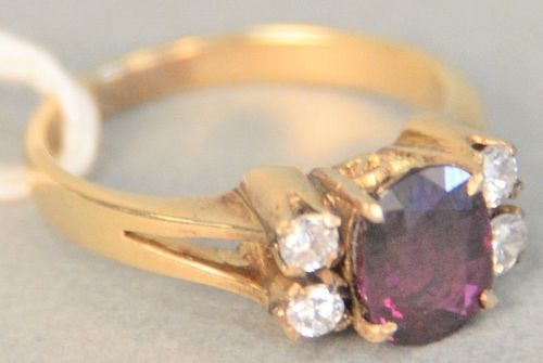 14k gold ring set with center oval ruby flanked b y 2 diamonds on either side, size 5.
