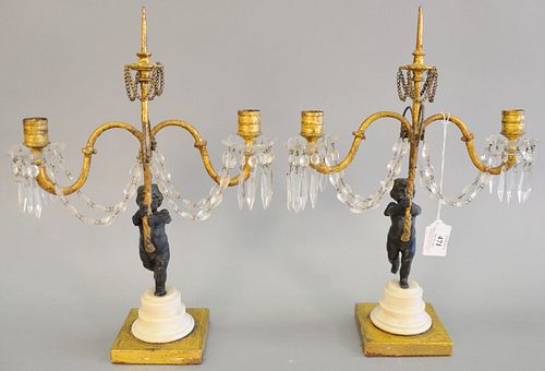Pair of Louis XVI French candelabras, having cherub support, holding two gilt scrolling arms with crystal, bobeche and prisms, pricket central support