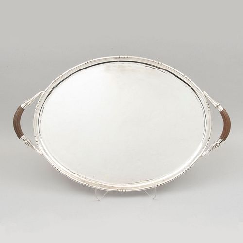 Charola. México. Siglo XX. Diseño oval. Elaborada en plata Sterling. Con asas de madera. Peso: 2,200 g.
