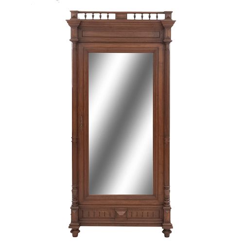 Armario. Francia. Siglo XX. En talla de madera de nogal. Con puerta con espejo de luna rectangular biselada. 235 x 109 x 60 cm.