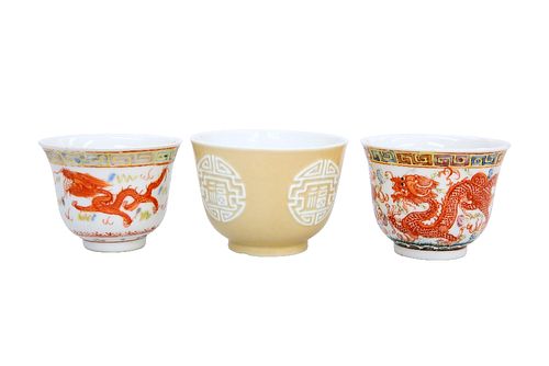 THREE CHINESE PORCELAIN WINE CUPS, the first brown-glazed and moulded with 