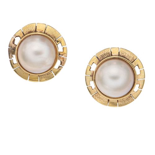 Par de aretes con medias perlas en oro amarillo de 10k. 2 medias perlas color gris de 11 mm. Peso: 6.3 g.