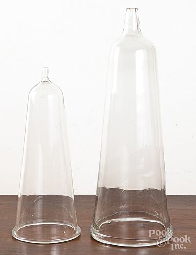 Two colorless glass funnels with open tops