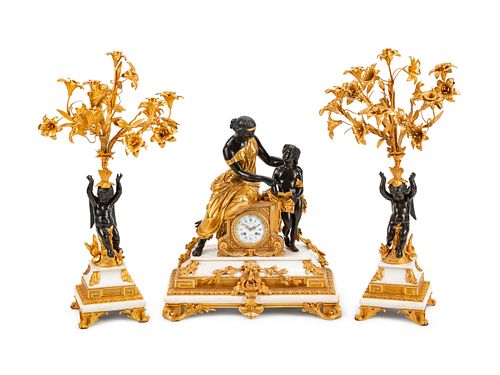 A Napoleon III Parcel-Gilt, Patinated Bronze and Marble Three-Piece Clock Garniture
Height of clock 25 x width 22 x depth 10 1/2 inches; height of can