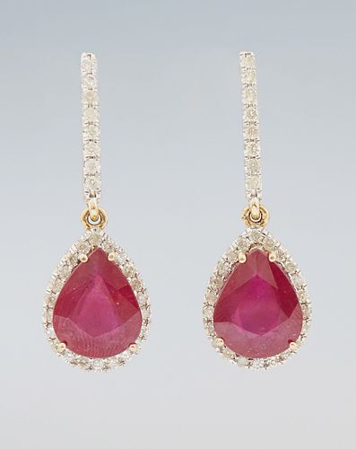 Pair of 14K Yellow Gold Pendant Earrings, each with a rigid diamond mounted link to a pear shaped pendant, with a pear shaped ruby a...