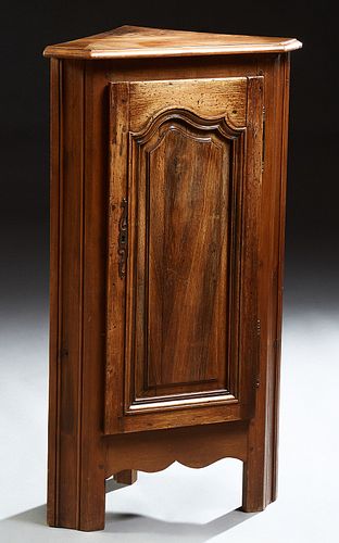 French Louis XIV Style Carved Oak Corner Cabinet, 20th c., the canted corner stepped edge top above an arched fielded panel door, on...