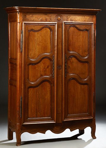 French Provincial Carved Oak Armoire, 19th c., the stepped rounded corner ogee crown over double three panel doors with iron fiche h...