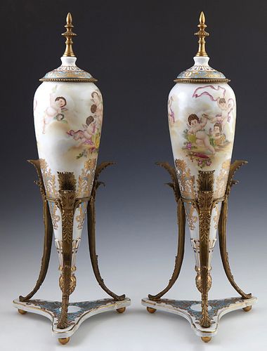 Pair of Sevres Style Bronze Mounted Covered Porcelain Urns, 19th c., of tapering form, with gilt and polychromed frolicking putti de...