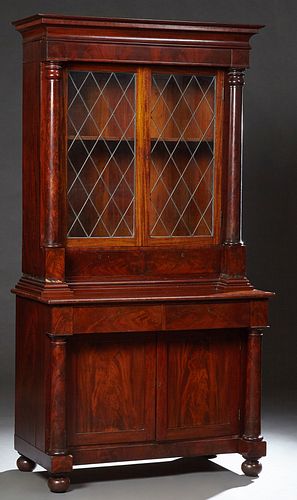 American Classical Mahogany Bookcase Cupboard, 20th c., the stepped ogee crown above leaded glazed double doors over two deep drawer...